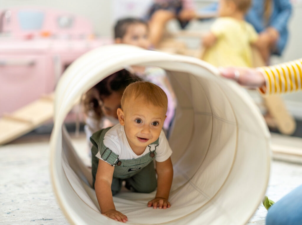 Child crawling through tunnel at daycare