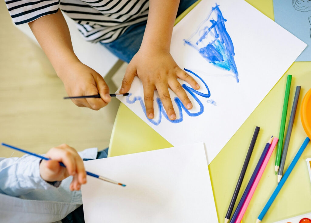 Child outlining hand with paint